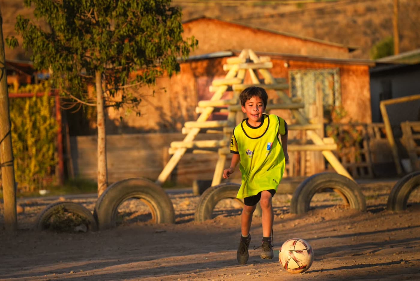 Niño con peto amarillo dominando el balón durante el entrenamiento