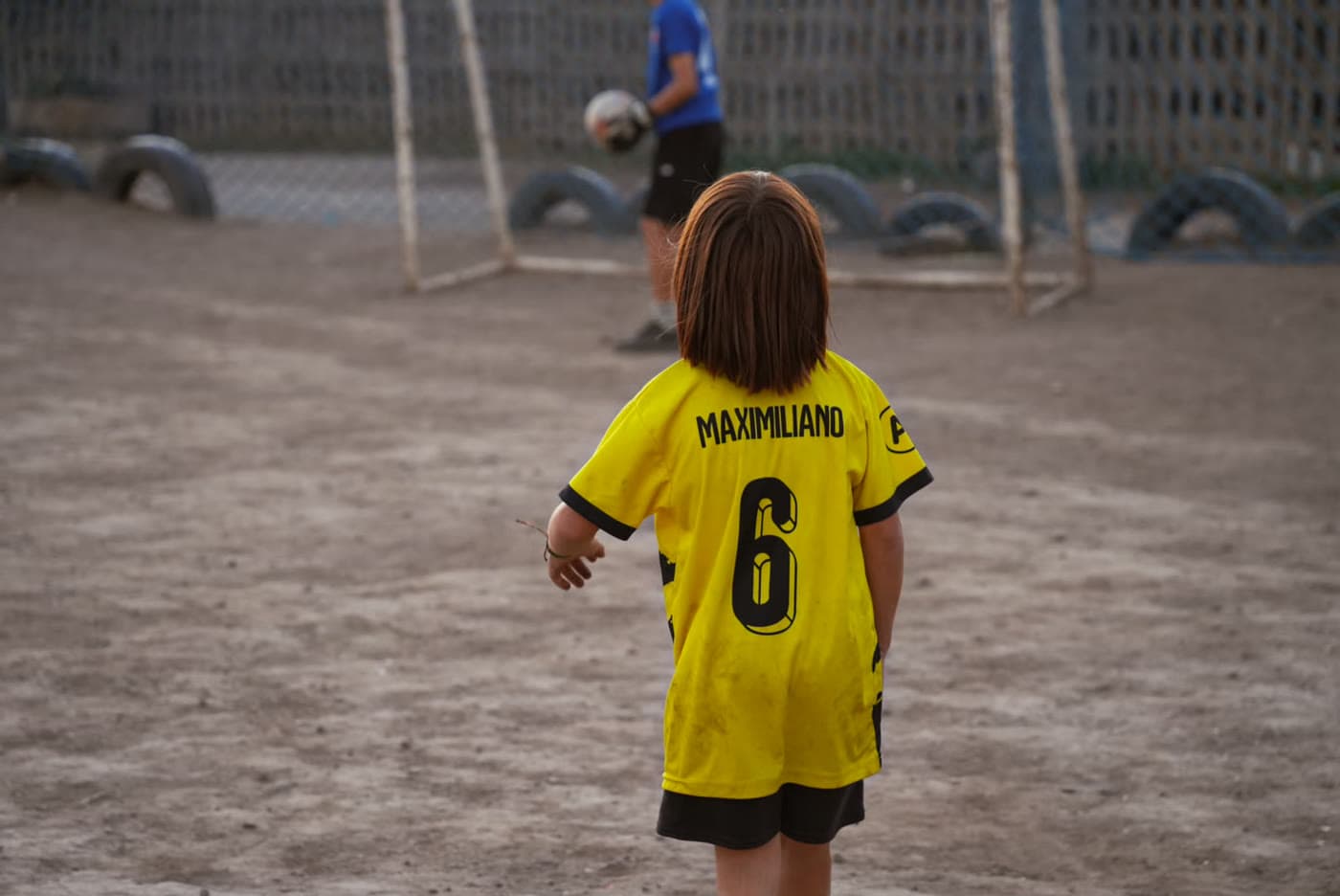Niña de espaldas con su camiseta personalizada, mirando hacia el arco